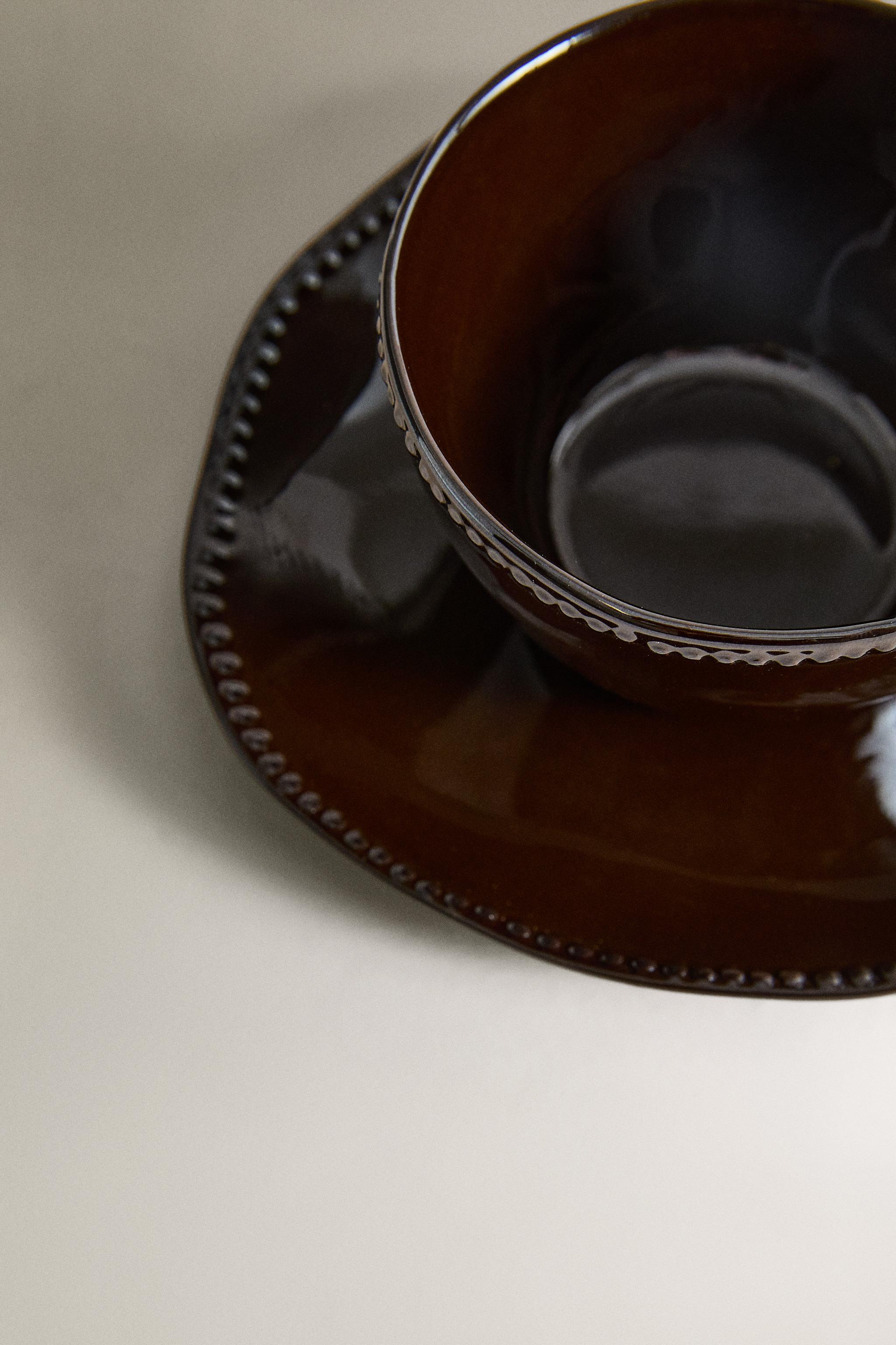 STONEWARE COFFEE CUP AND SAUCER WITH RAISED DESIGN